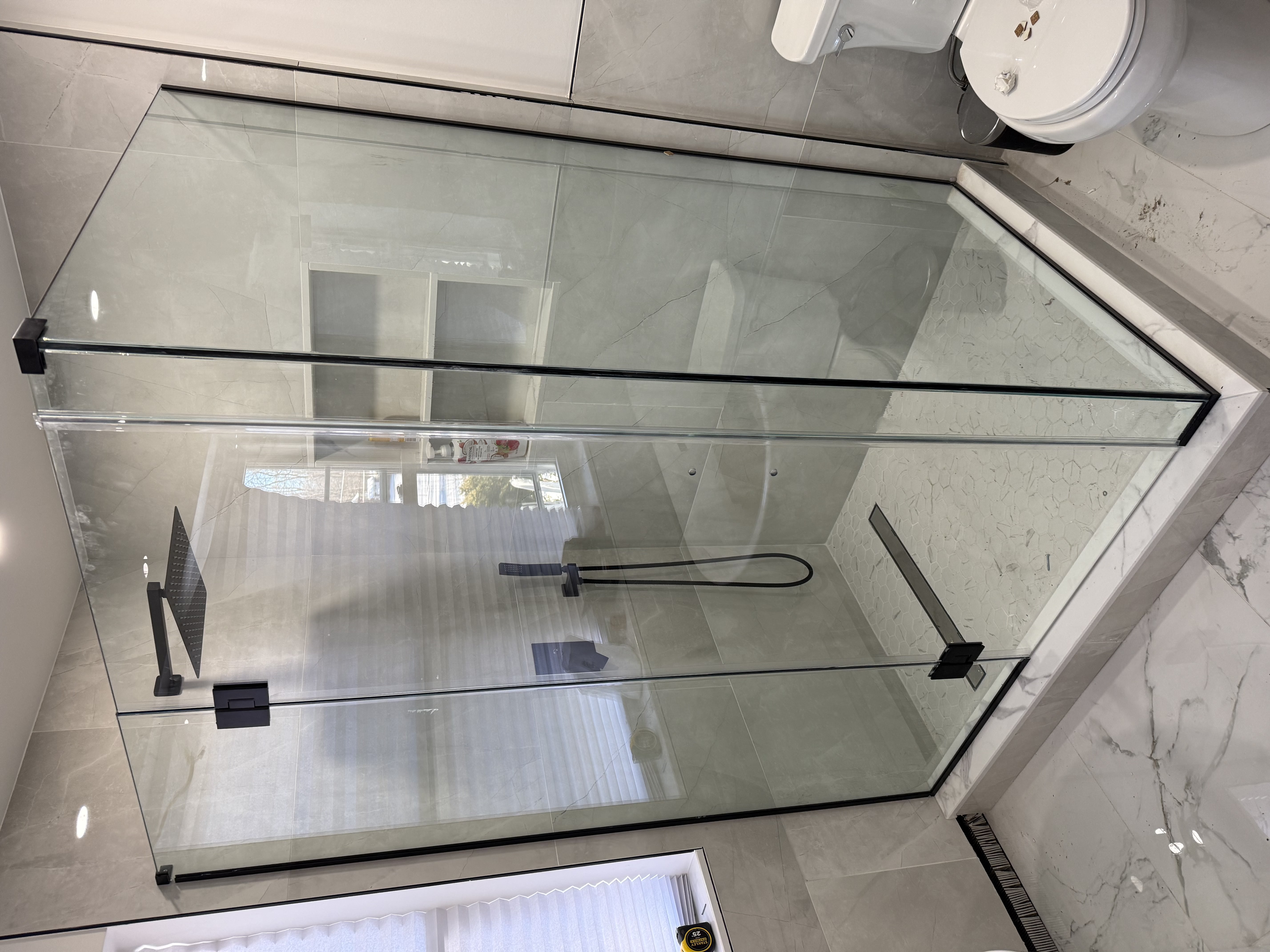 Frameless glass shower enclosure with black hardware